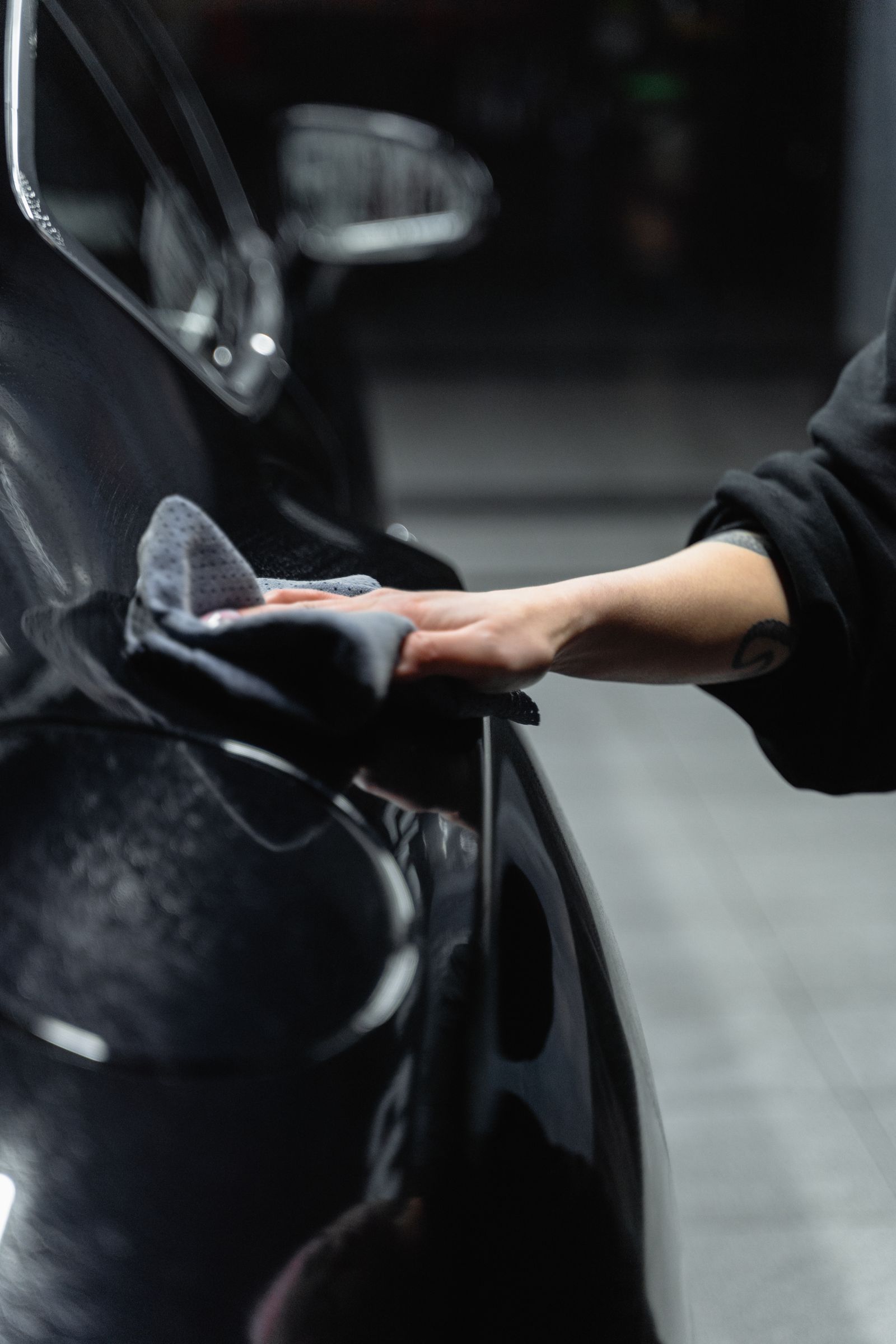 Detailer aan het werk aan de carrosserie van een wagen in de werkplaats