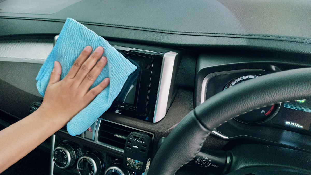 Auto-interieur wordt grondig gereinigd met borstel en reinigingsmiddel
