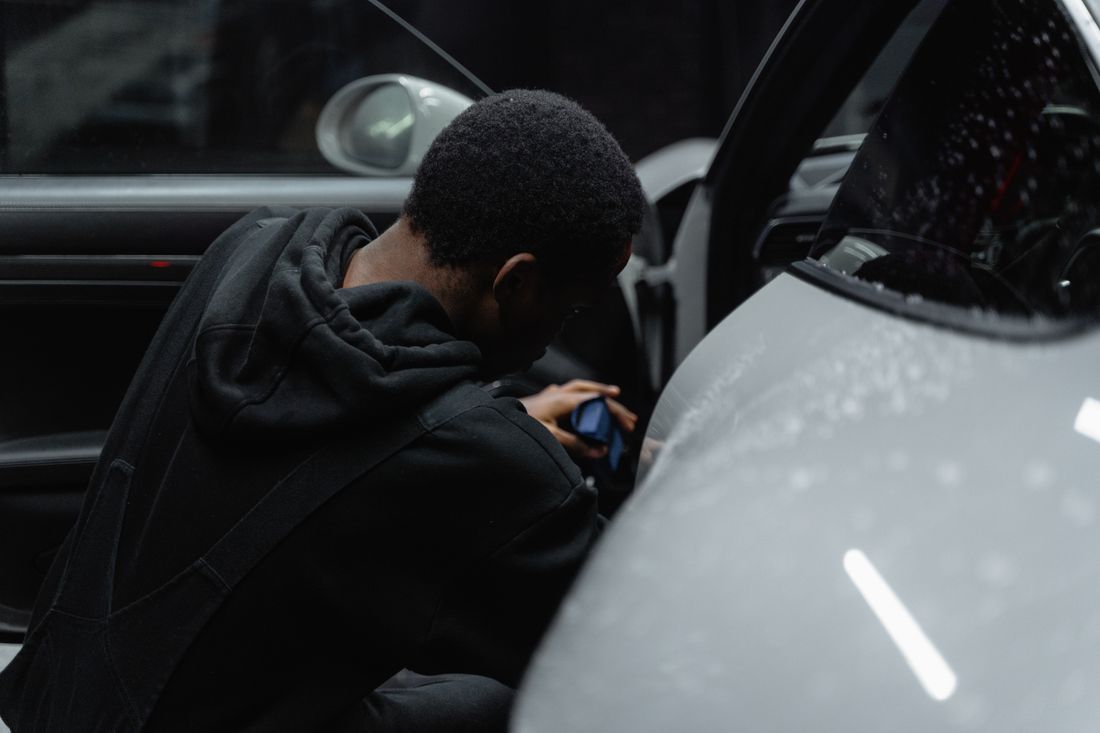 Detailer werkt aan de carrosserie van een wagen