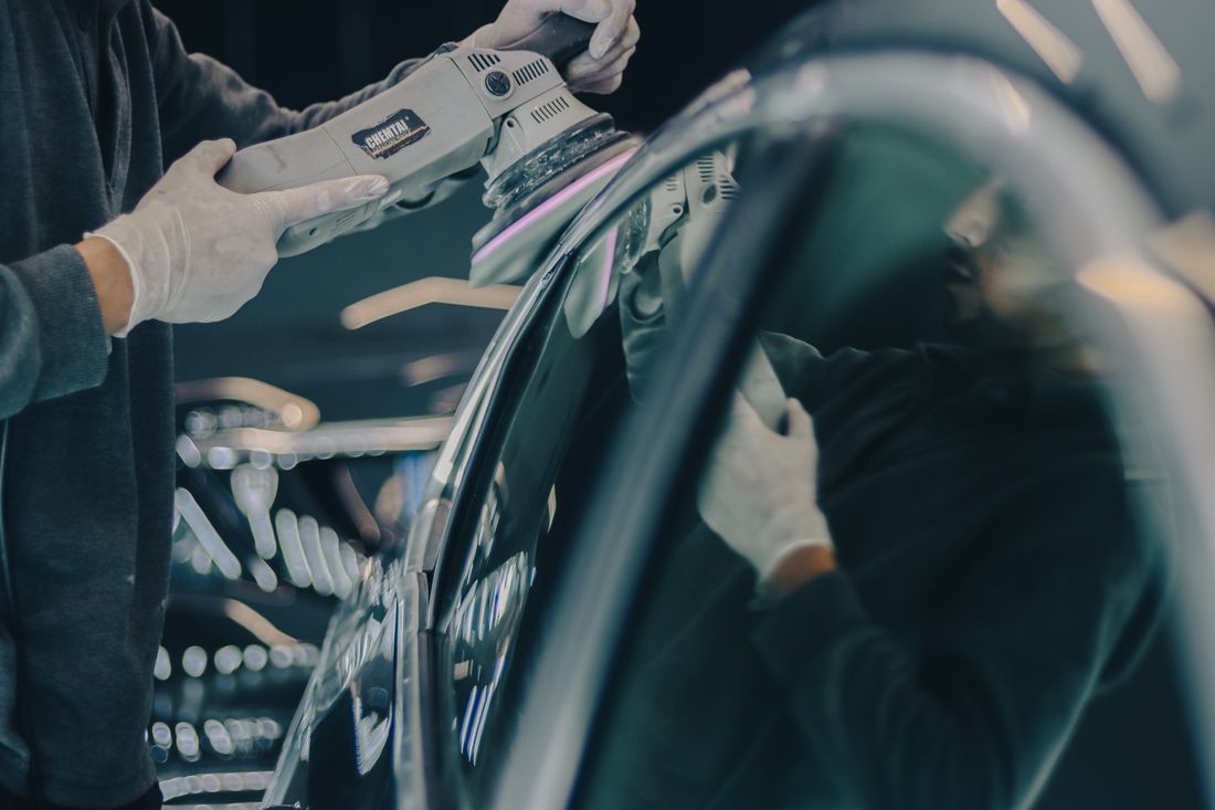 Polijstmachine op een autopaneel in de werkplaats